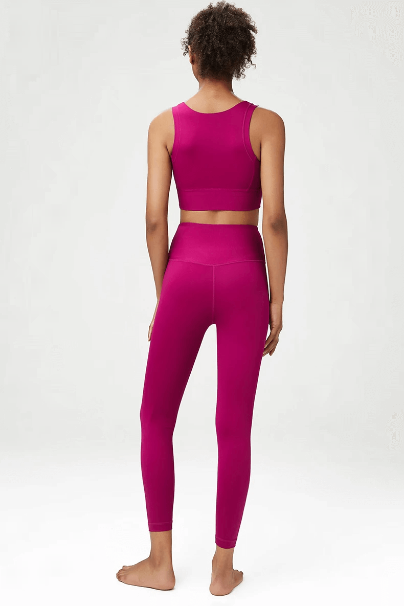 Woman wearing seamless yoga gear set in vivid pink, featuring a sports bra and leggings, ideal for yoga and fitness. SF2086